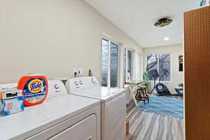 Laundry area with light wood-style flooring and separate washer and dryer