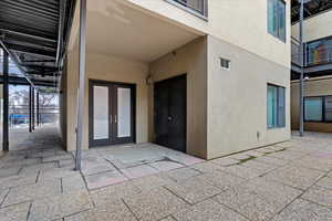 Property entrance with stucco siding, french doors, and a patio