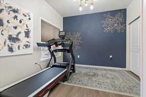 Exercise room featuring light wood finished floors and baseboards