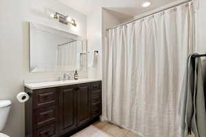 Full bath with vanity, a shower with curtain, and light tile patterned flooring
