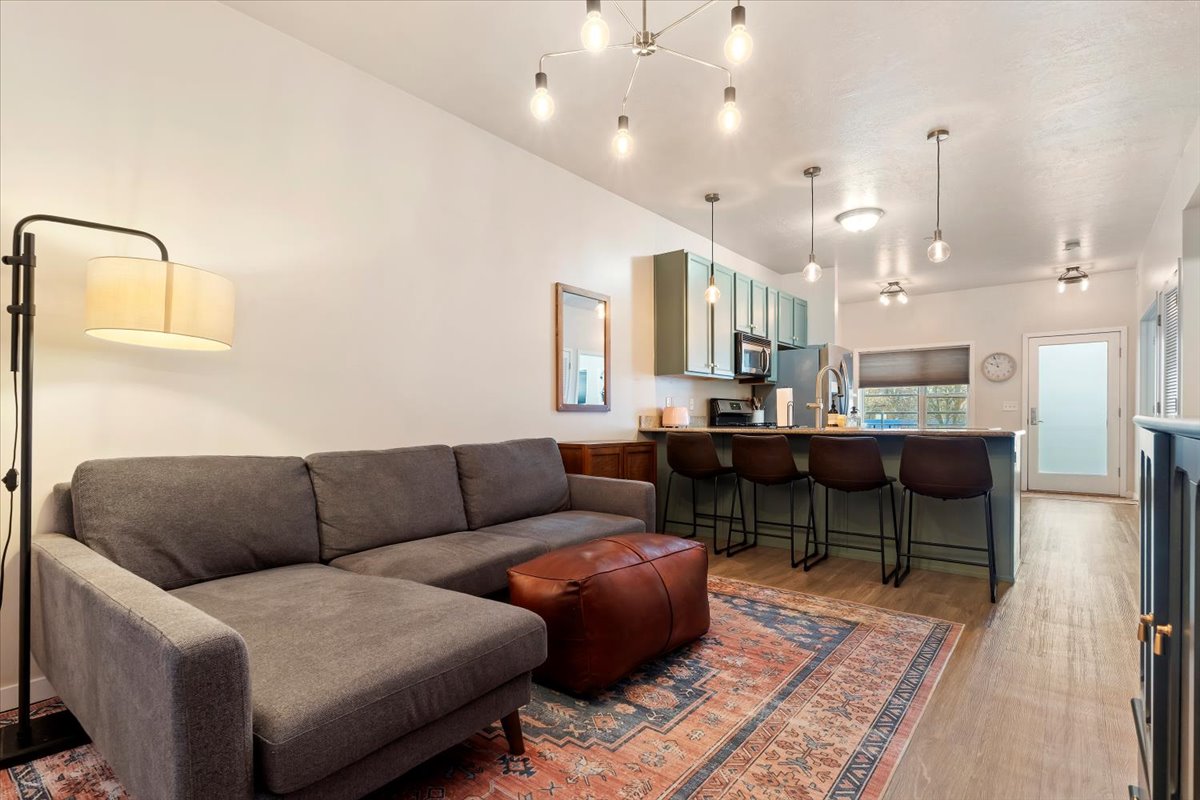 Living room featuring light wood finished floors and hanging lights