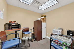Office space featuring a paneled ceiling and light colored carpet