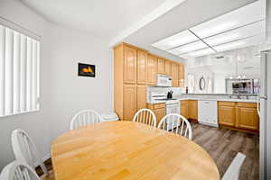 Dining room with light wood-style floors and suspended lighting