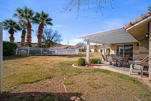 Fenced backyard featuring a patio area, a pergola, outdoor dining area, and a residential view