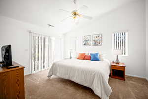 Bedroom with access to exterior, carpet flooring, lofted ceiling, and a ceiling fan