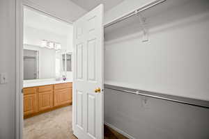Walk in closet featuring light colored carpet