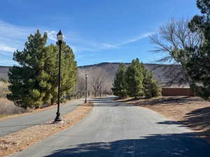 View of asphalt street featuring street lighting and a mountain view