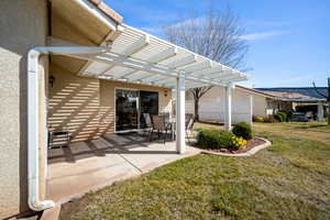 Rear view of property with a pergola, stucco siding, and a patio area