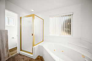 Bathroom with a shower stall and a whirlpool tub