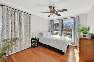 Bedroom with wood finished floors, a ceiling fan, and ornamental molding