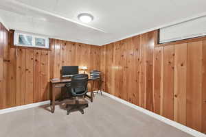 Office with carpet floors and wooden walls
