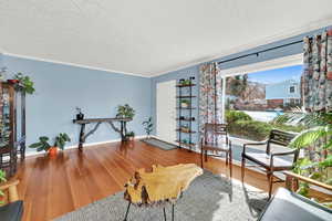 Sitting room with wood finished floors and a textured ceiling