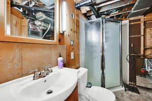 3/4 bathroom featuring a shower stall, vanity, and stone finish floors
