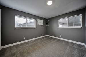 Carpeted empty room featuring baseboards