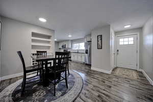 Dining area featuring dark wood finished floors and built in shelves