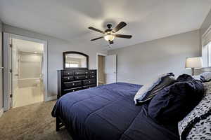 Bedroom featuring ceiling fan, carpet, and connected bathroom