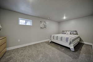 Bedroom featuring light carpet and a textured ceiling