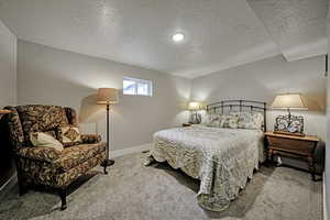 Carpeted bedroom with a textured ceiling and baseboards