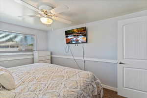 Bedroom featuring dark colored carpet and ceiling fan