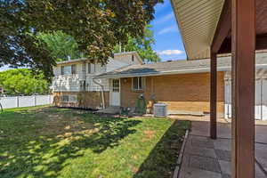 Back of house with brick siding, a shingled roof, and entry steps
