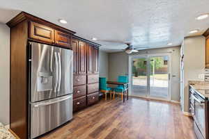 Kitchen featuring stainless steel appliances, recessed lighting, light wood-style flooring, a textured ceiling, and a ceiling fan