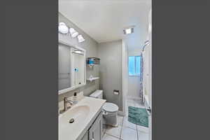 Bathroom with vanity, light tile patterned flooring, and shower / bathtub combination with curtain