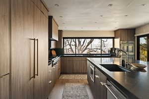 Kitchen featuring modern cabinets, recessed lighting, stainless steel appliances, and light wood finished floors