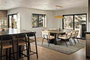Dining area featuring light wood finished floors, plenty of natural light, and recessed lighting