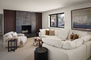 Carpeted living room featuring a tiled fireplace and recessed lighting