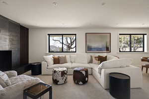 Carpeted living area featuring healthy amount of natural light and a high end fireplace