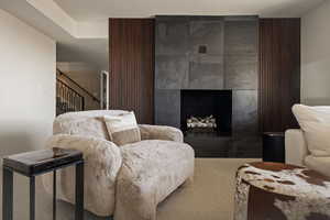 Sitting room with a tiled fireplace and carpet floors