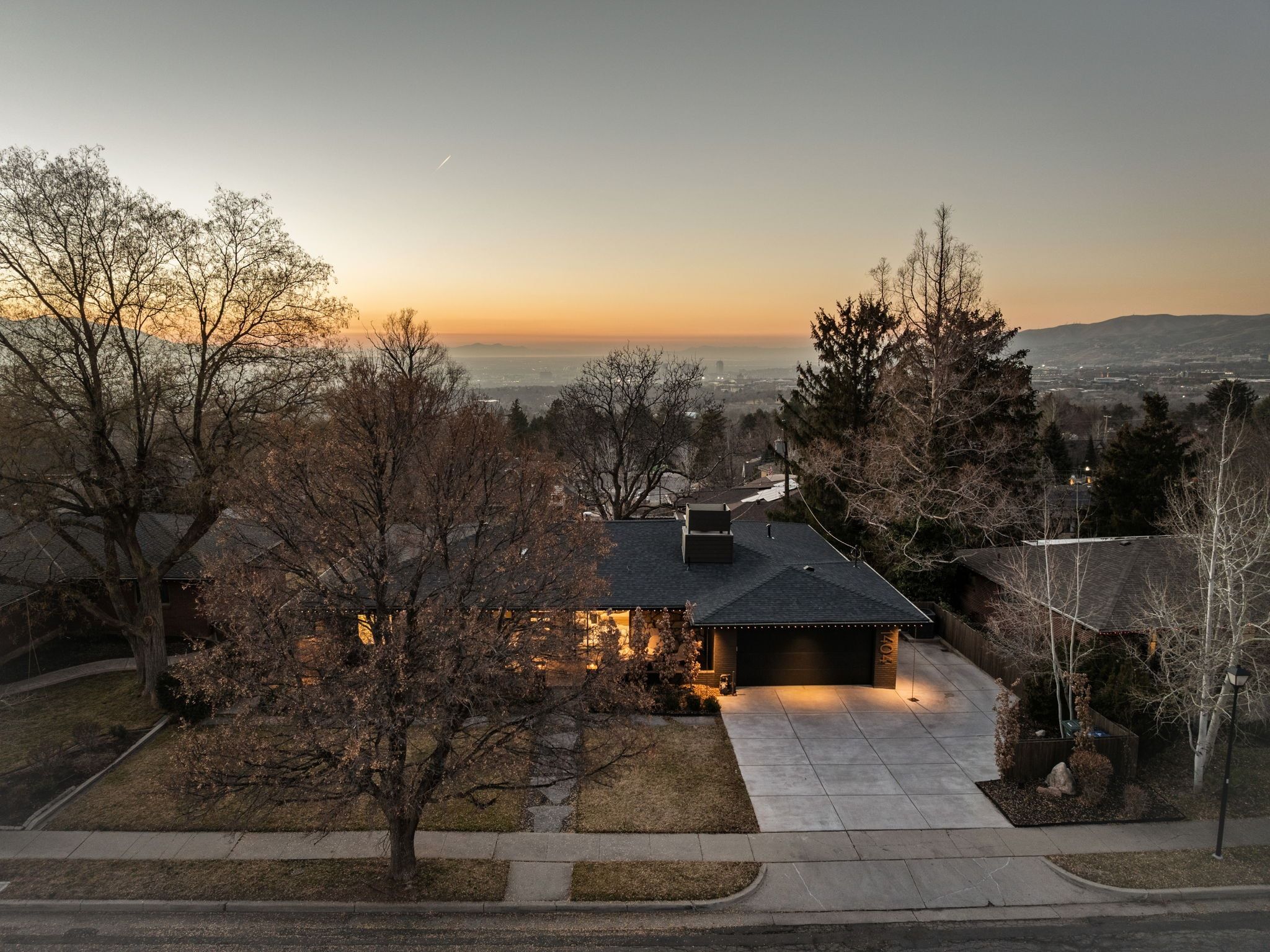 View of front of house featuring driveway, a shingled roof, and a garage