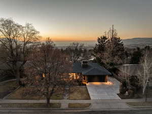 View of front of house featuring driveway, a shingled roof, and a garage