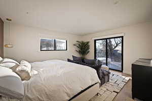 Bedroom featuring access to exterior and wood finished floors