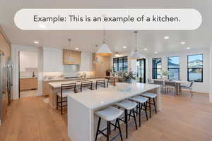 Two tone kitchen with a kitchen breakfast bar, decorative light fixtures, light wood-style floors, dual tone cabinetry, and light stone countertops