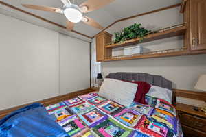Bedroom with lofted ceiling, ceiling fan, and crown molding