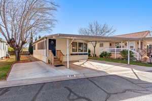 View of front facade with a carport, entry steps, and a porch