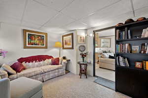 Carpeted living area with a paneled ceiling