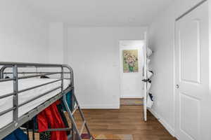 Bedroom with wood finished floors and baseboards