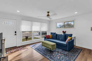 Living area with wood finished floors, a ceiling fan, and recessed lighting