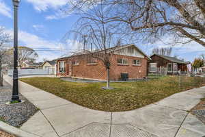 View of side of home with brick siding and a central AC unit