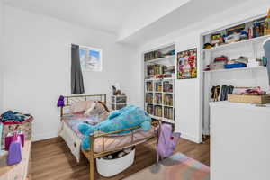Bedroom featuring light wood-style floors and lofted ceiling