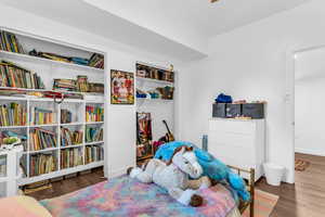 Bedroom with dark wood-style floors and a closet