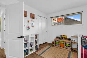 Playroom with wood finished floors and baseboards