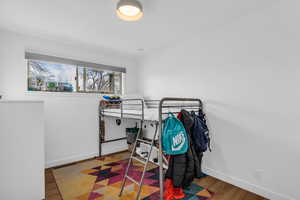 Bedroom with wood finished floors and baseboards