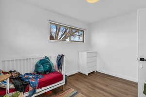 Bedroom featuring wood finished floors and baseboards