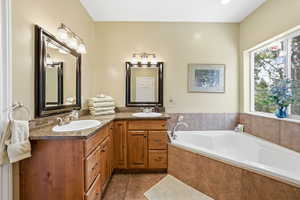 Full bath featuring double vanity, a bath, and tile patterned floors