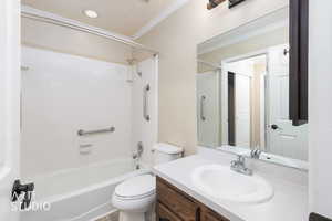 Full bath featuring vanity, crown molding, and washtub / shower combination