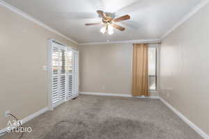 Empty room with ceiling fan, light colored carpet, and crown molding