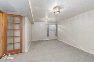 Spare room with a textured ceiling and light carpet